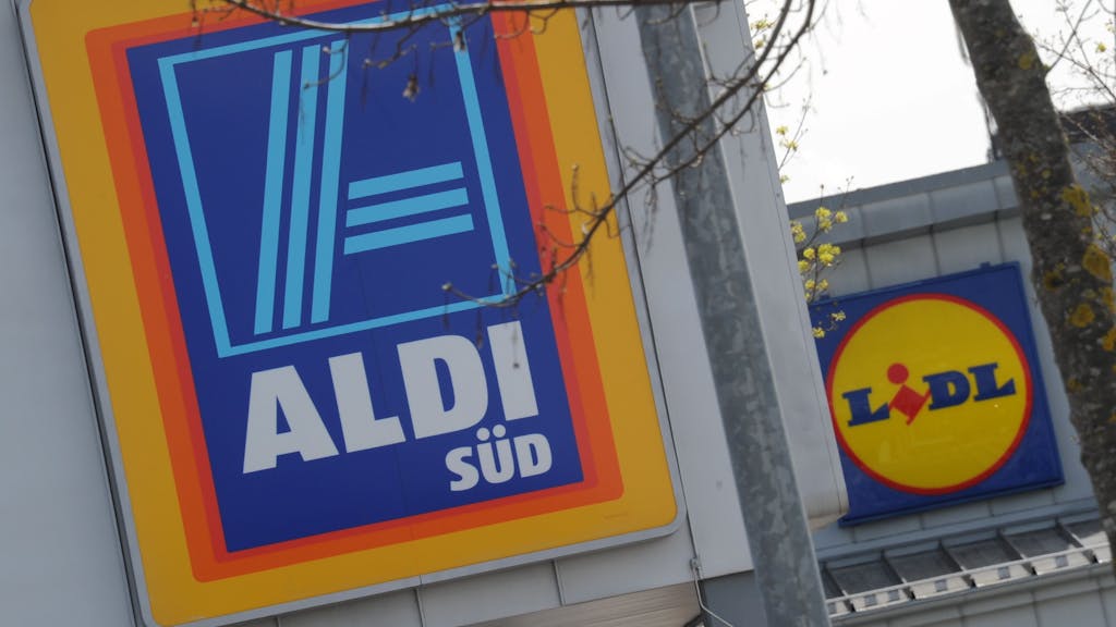 Die Logos der Discount-Supermärkte Aldi und Lidl hängen am 21. April 2012 in Unterhaching bei München (Oberbayern) an zwei Filialen der Unternehmen, die in unmittelbarer Nachbarschaft stehen.