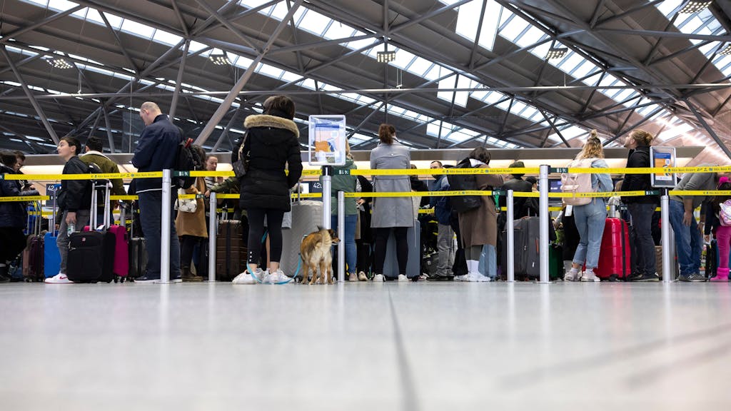 Reisende am Flughafen Köln/Bonn stehen in der Abflughalle an den Check-In Schaltern.&nbsp;