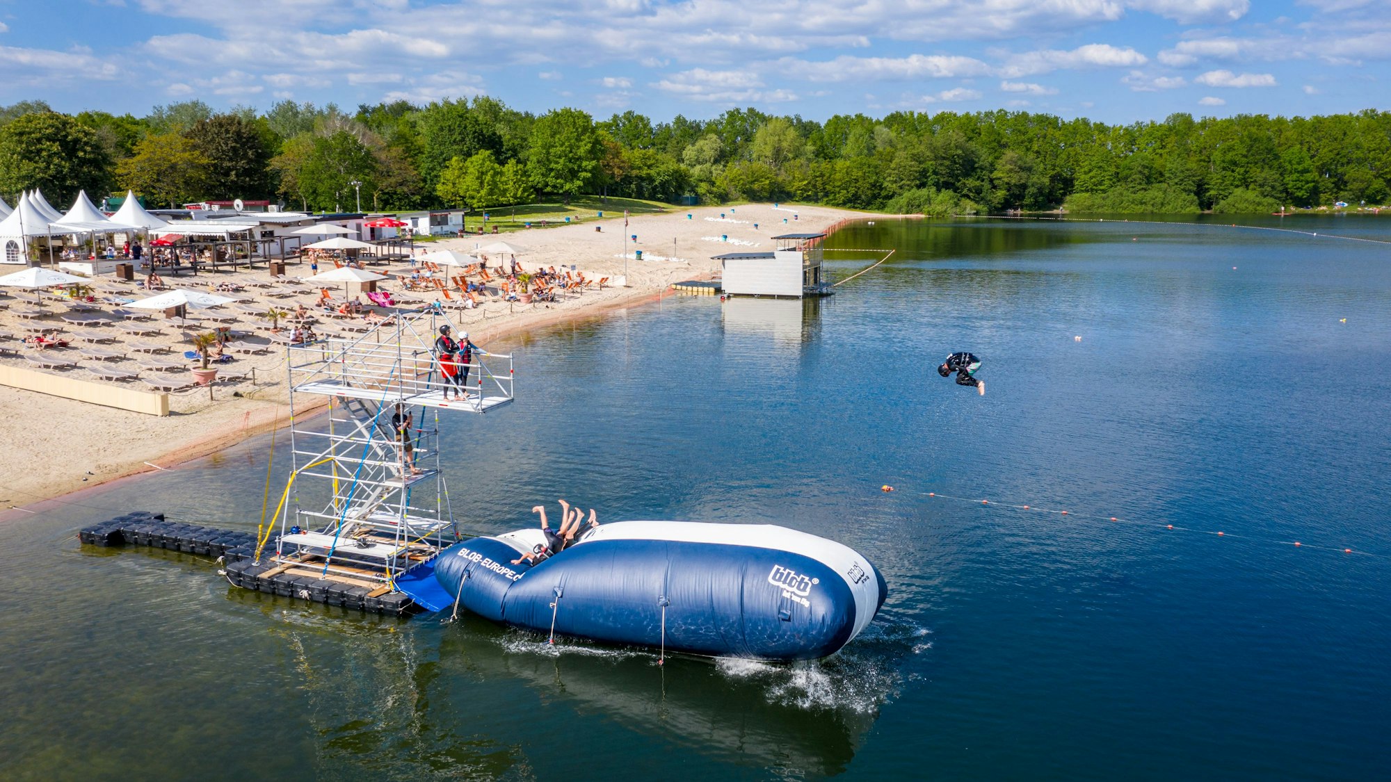 Turmspringer der Splashdiving-Gruppe „Cologne Bombs“ springen am Otto-Maigler-See von einem sogenannten „Blob“ ins Wasser. Hierbei liegen die Personen auf einem Luftkissen und werden in die Luft geschleudert, wenn am hinteren Ende ein oder mehrere Personen auf das Kissen springen.