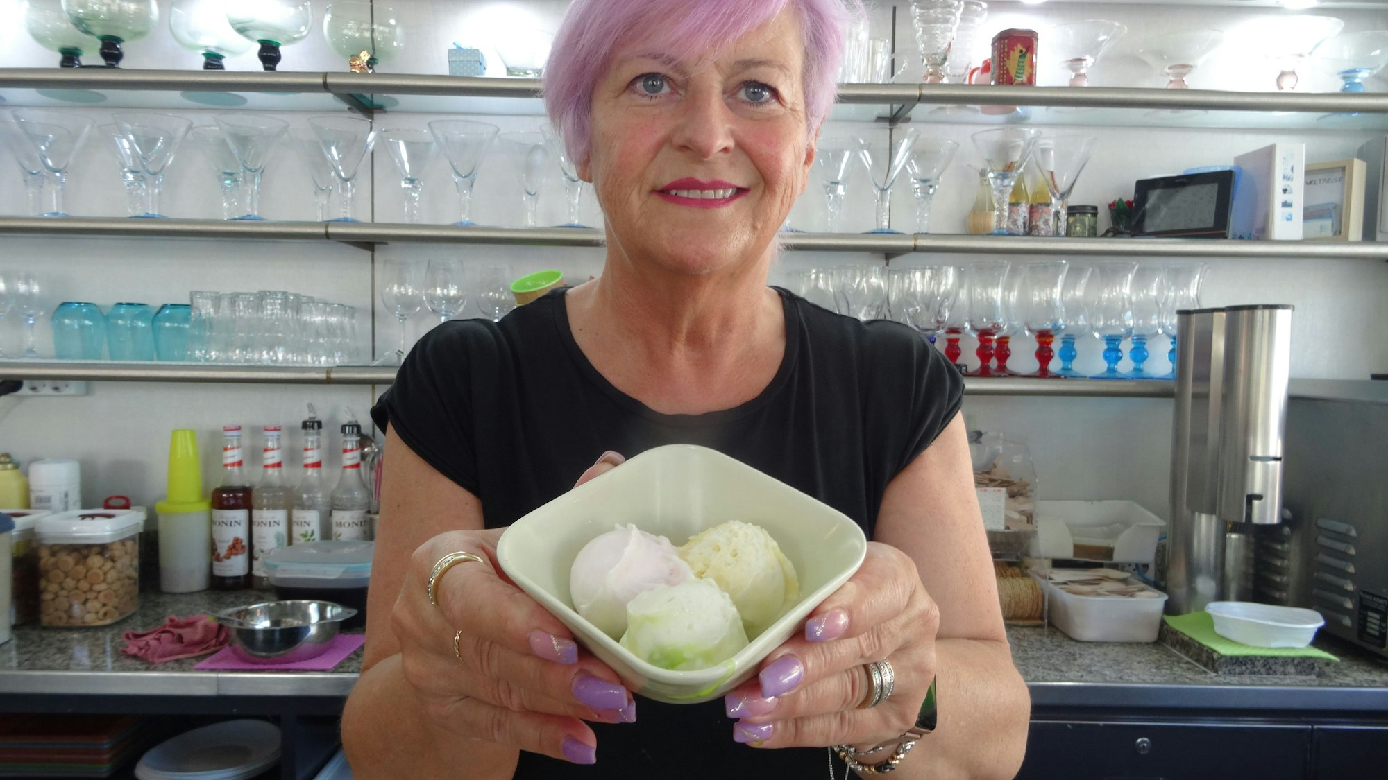 Luciana De Ronch, Chefin des Eiscafés Fontanella in Troisdorf, kreiert dauernd neue Sorten. Aktuell empfiehlt sie Quark-Limette, Grapefruit und  Buttermilch-Orange. Ein Schildchen in der Vitrine weist auf das Eis der Woche hin.