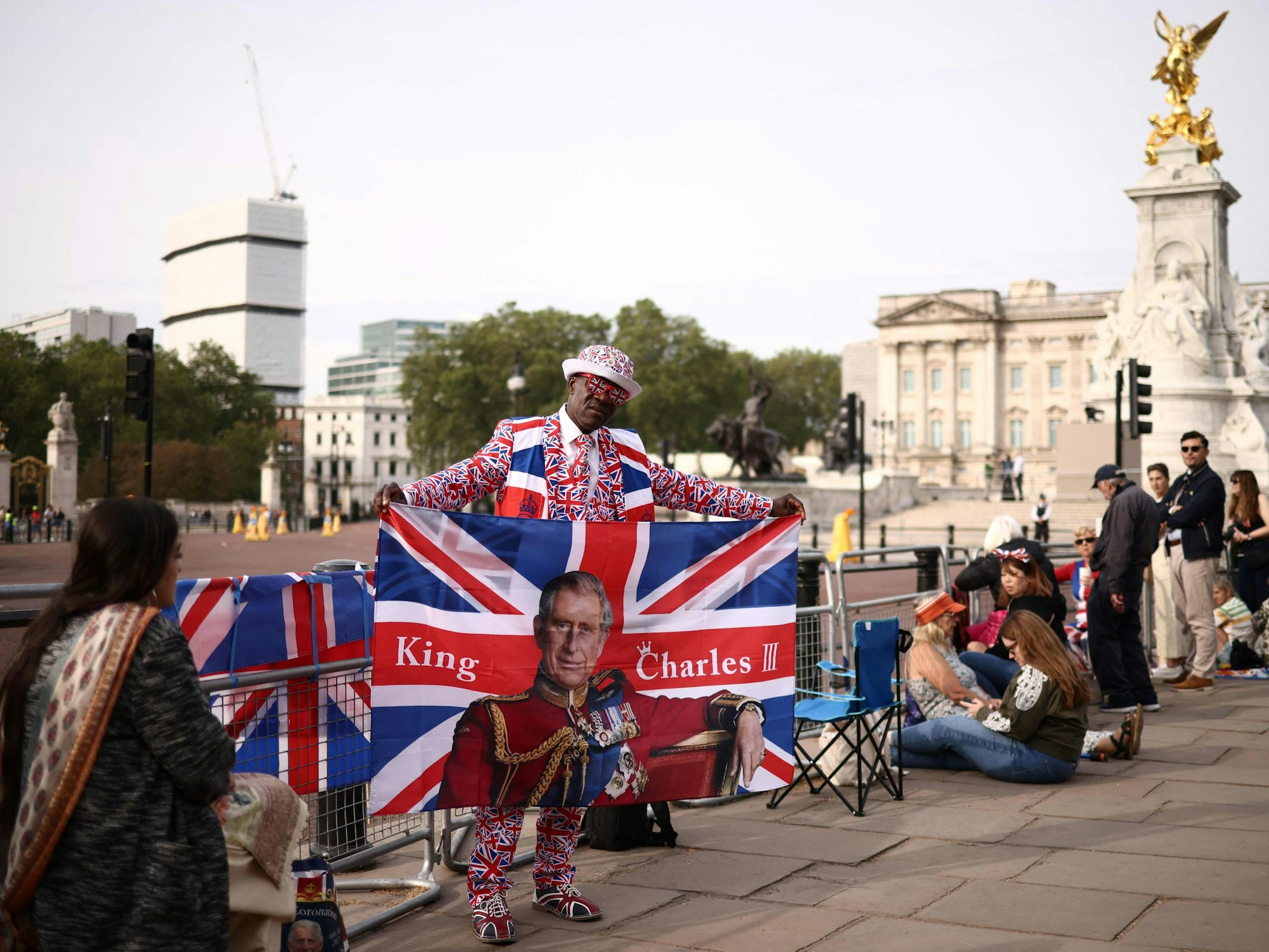 Ein königlicher Superfan posiert am Queen Victoria Memorial vor dem Buckingham Palace vor der Parade zum Geburtstag des Königs, „Trooping the Colour“, in London am 17. Juni 2023.