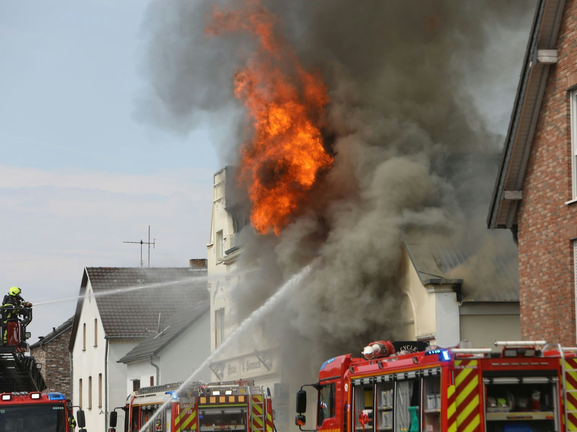 Flammen lodern aus dem Dach des Hauses.