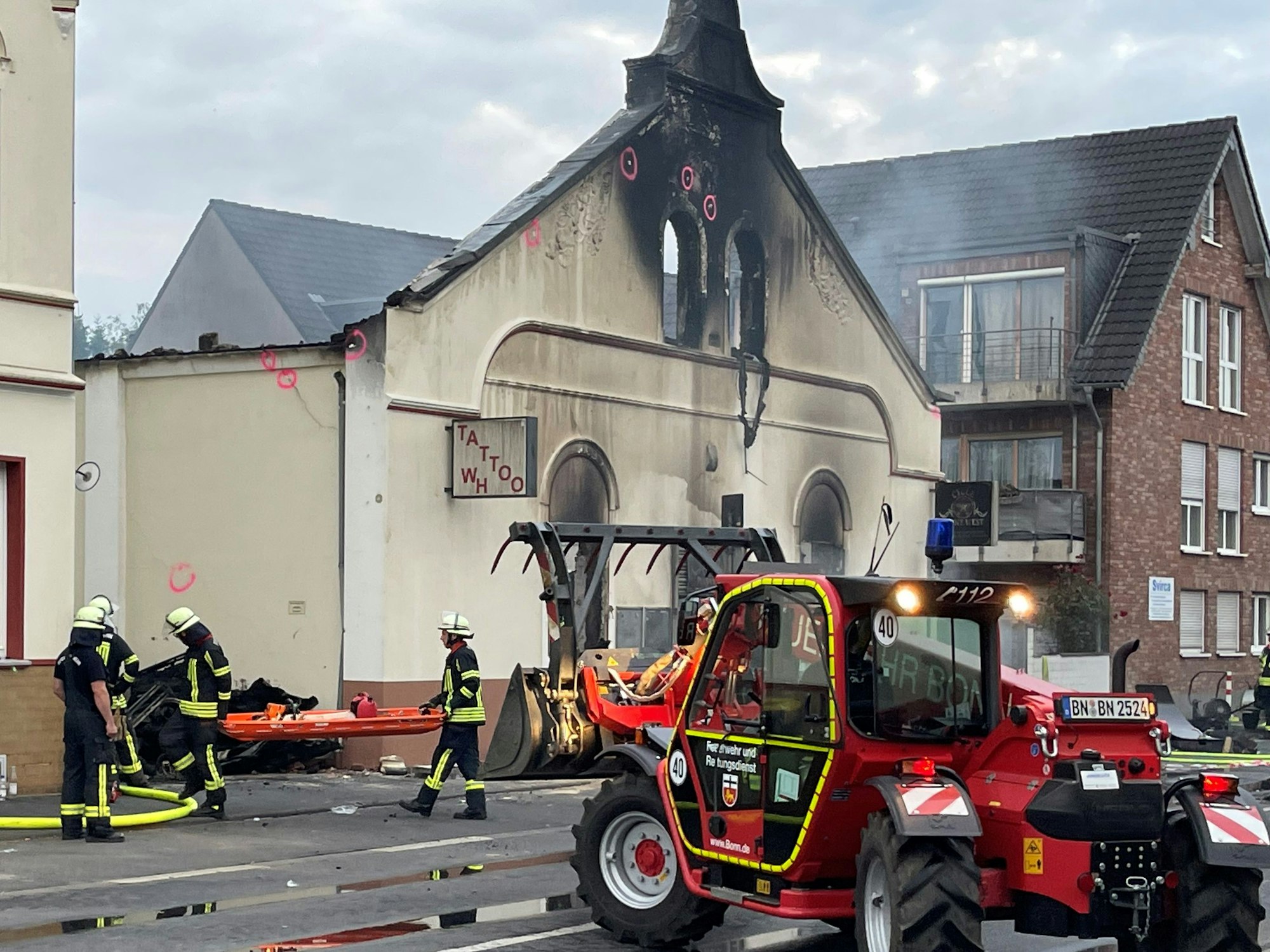 Die Bergung hat begonnen, die Feuerwehr Bonn räumt  mit schwerem Gerät verbrannte Trümmer weg.