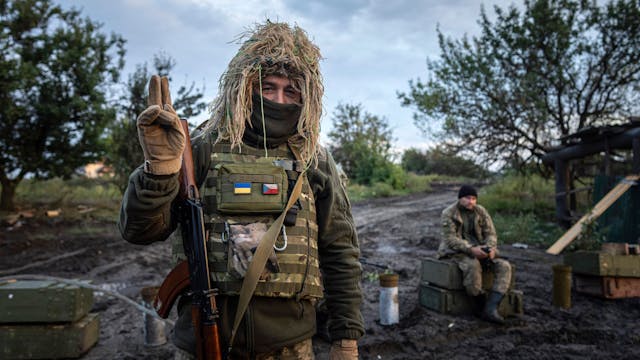 Ein ukrainischer Soldat zeigt ein Peace-Zeichen, während er seine Position am Kontrollpunkt bewacht. (Symbolbild)