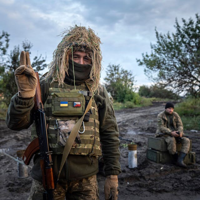Ein ukrainischer Soldat zeigt ein Peace-Zeichen, während er seine Position am Kontrollpunkt bewacht. (Symbolbild)