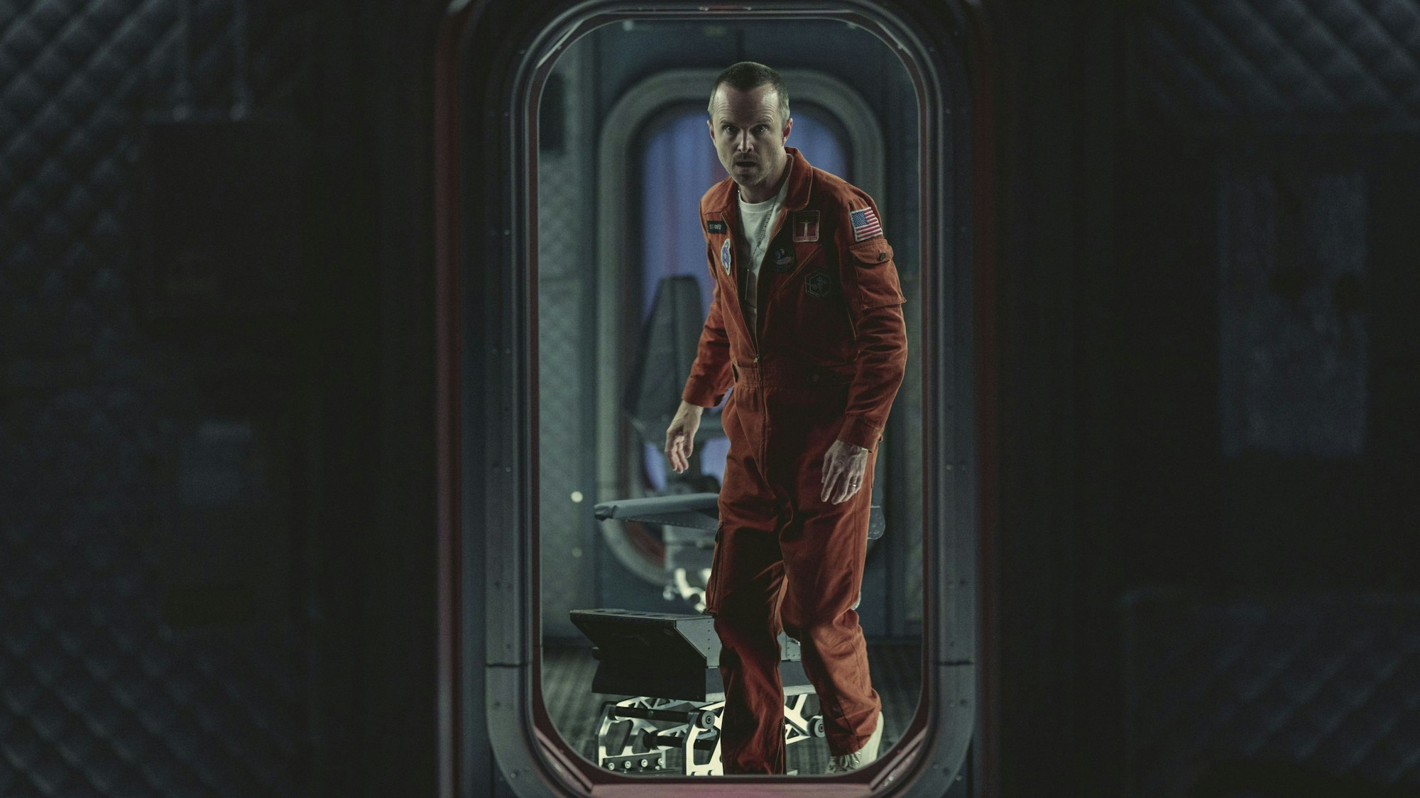 Ein Mann geht durch eine Tür in einem Raumschiff.