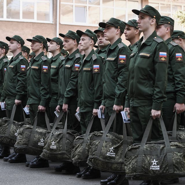 Wehrpflichtige stehen in Formation, bevor sie die Stadt verlassen, um in der russischen Armee zu dienen. Sie tragen grüne Uniform und haben eine Tasche in der Hand.&nbsp;
