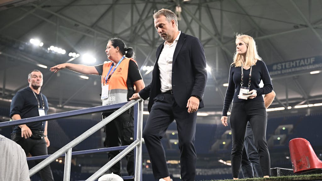 Bundestrainer Hansi Flick geht eine Treppe hinunter zur Pressekonferenz nach dem Spiel.