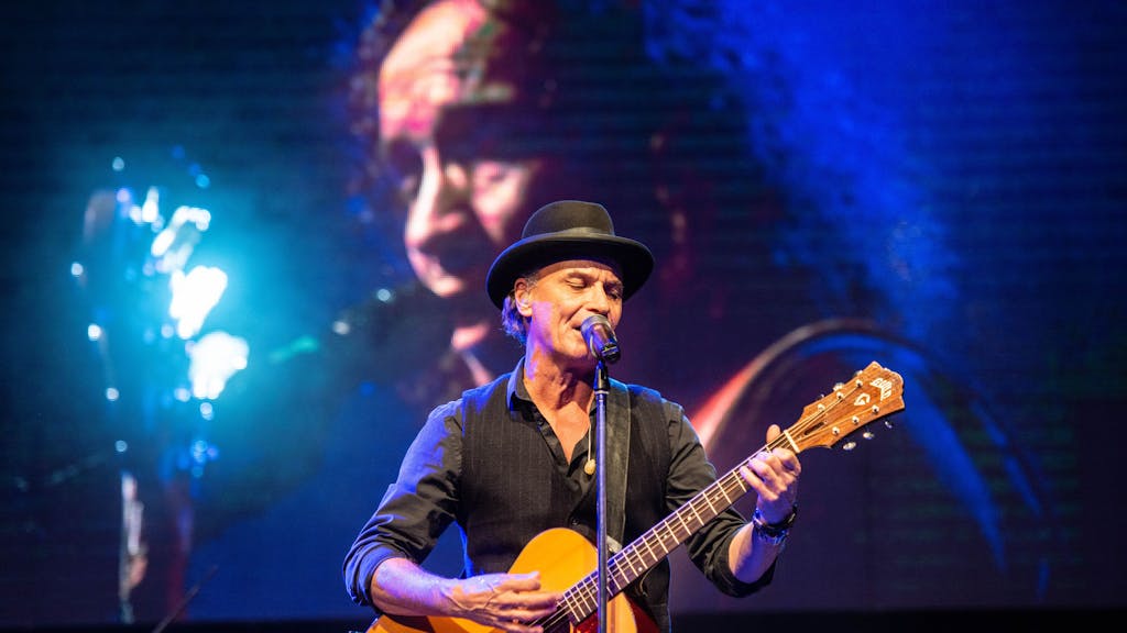 Peter Brings steht mit Gitarre auf der Bühne im Kölner Tanzbrunnen und singt.
