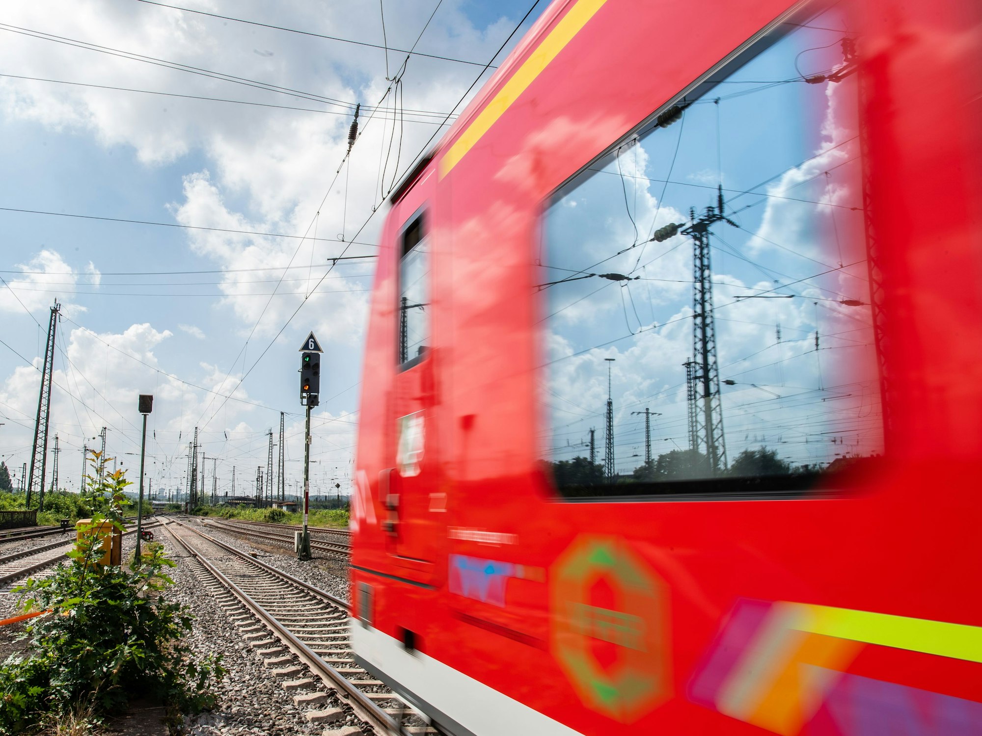 In der Scheibe einer Regionalbahn, die Richtung Dortmund fährt, spiegeln sich Hochspannungsleitungen, hier im Mai 2018.
