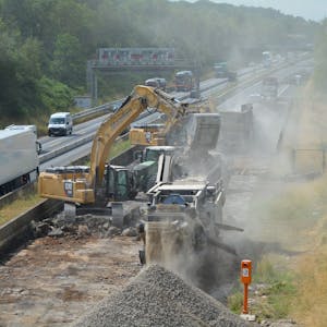Auf dem Bild ist eine Baustelle mit Baggern und aufgerissener Fahrbahn auf der Autobahn A61 zu sehen.