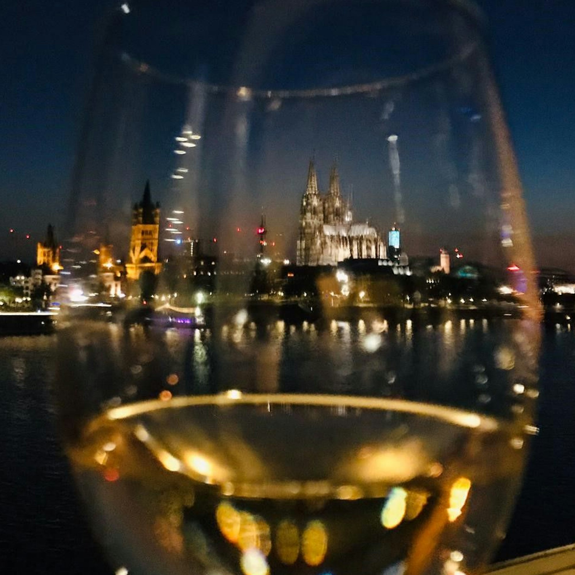 Das Stadtpanorama abends durch ein Weinglas gesehen