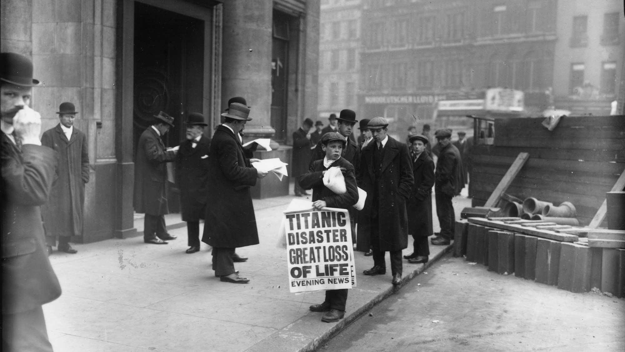 Der Zeitungsverkäufer Ned Parfett verkauft am 16. April 1912 vor dem Oceanic House, dem Londoner Büro der Titanic-Reederei White Star Line, in der Cockspur Street in London Exemplare der „Evening News“, die über den Untergang der Titanic berichten.