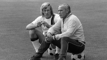 Hennes Weisweiler (r.), Trainer-Legende von Borussia Mönchengladbach, im Gespräch mit seinem Spielmacher Günter Netzer (l.). Dieses Foto zeigt die beiden am 25. Juli 1971. Die beiden sitzen jeweils auf einem Fußball.