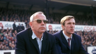 Hennes Weisweiler (l.), verstorbener Legenden-Trainer von Borussia Mönchengladbach, hier gemeinsam mit Fohlen-Spielmacher Günter Netzer. Das Foto ist am 1. September 1968 entstanden. Die beiden sitzen auf der Bank und schauen auf das Spielfeld.