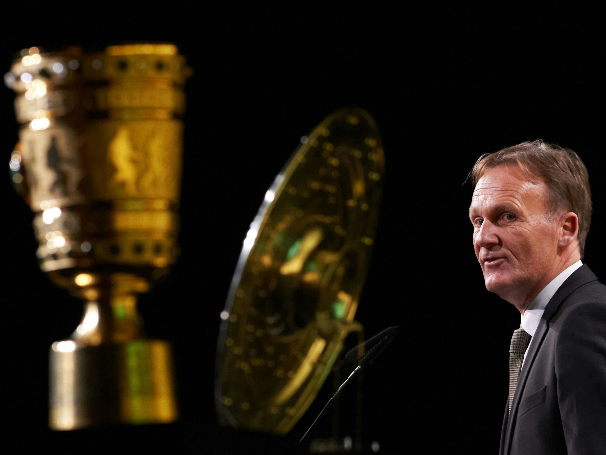 BVB-Geschäftsführer Hans-Joachim Watzke redet in der Westfalenhalle in Dortmund hinter der Meisterschale und dem DFB-Pokal.