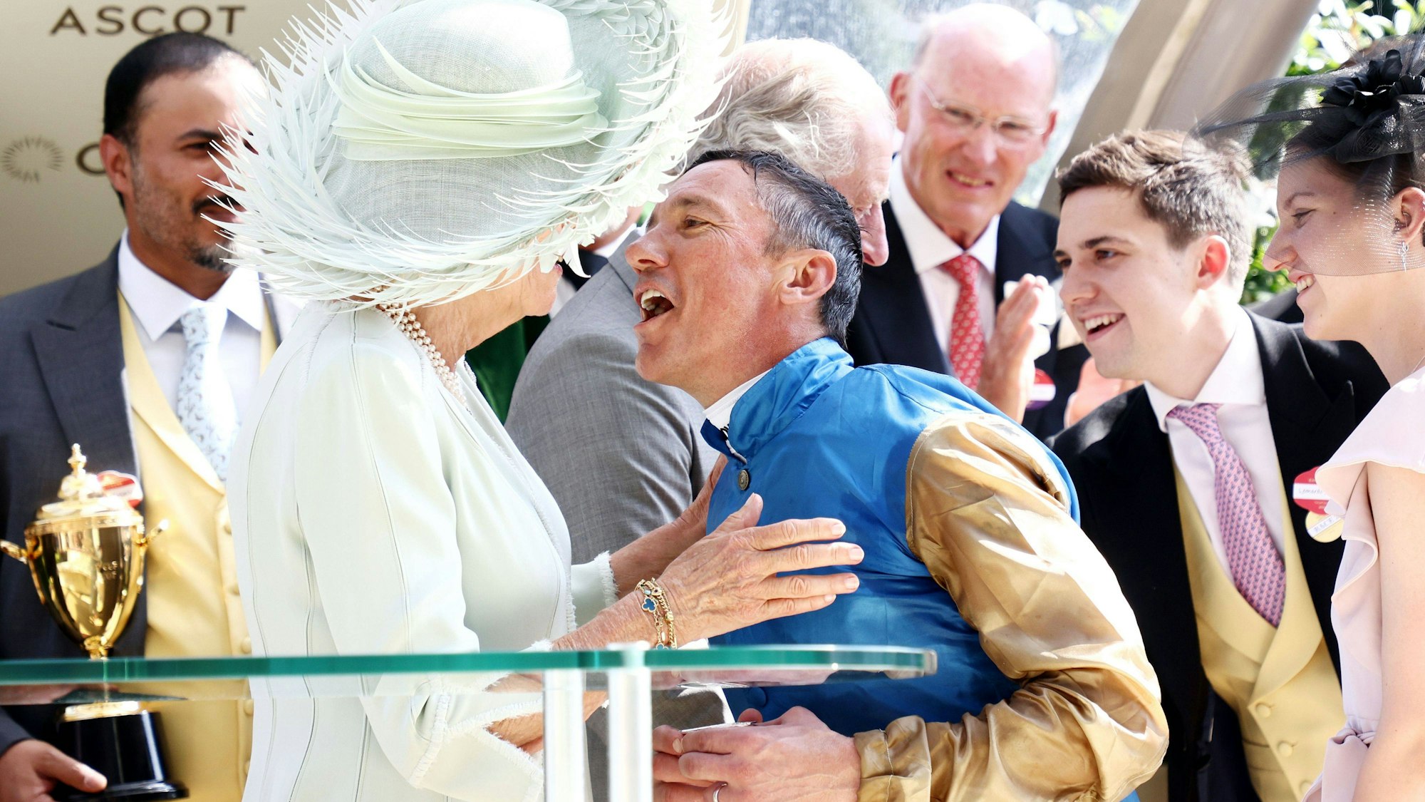 Das Royal Ascot hat einen Aufreger: Der Jockey Frankie Dettori bricht das königliche Protokoll und gibt Camilla einen Kuss, während er sich über den Gold-Cup-Sieg freut.