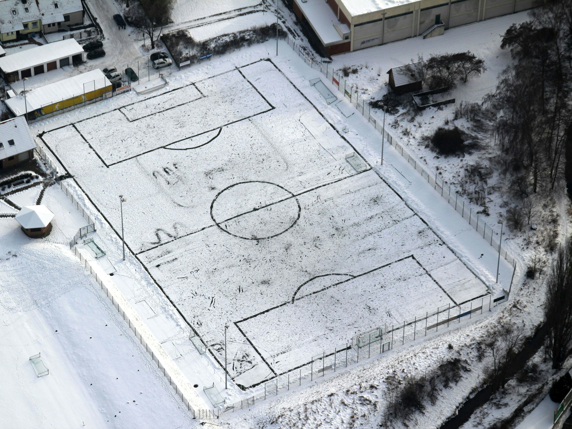 Luftaufnahme zeigt einen mit Schnee bedeckten Fußballplatz in Duderstadt (Niedersachsen).