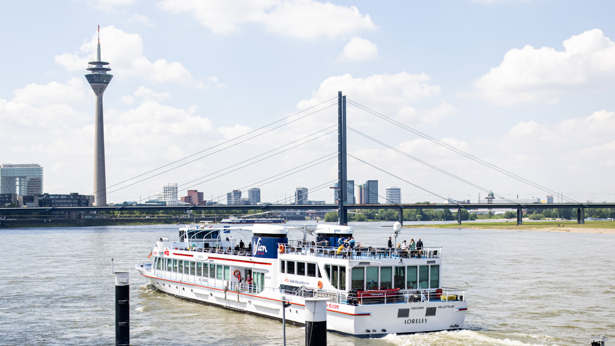 Das Ausflugsschiff „MS Loreley“ startet auf dem Rhein in Düsseldorf in Richtung Köln. Im Hintergrund ist der Düsseldorfer Fernsehturm zu sehen.
