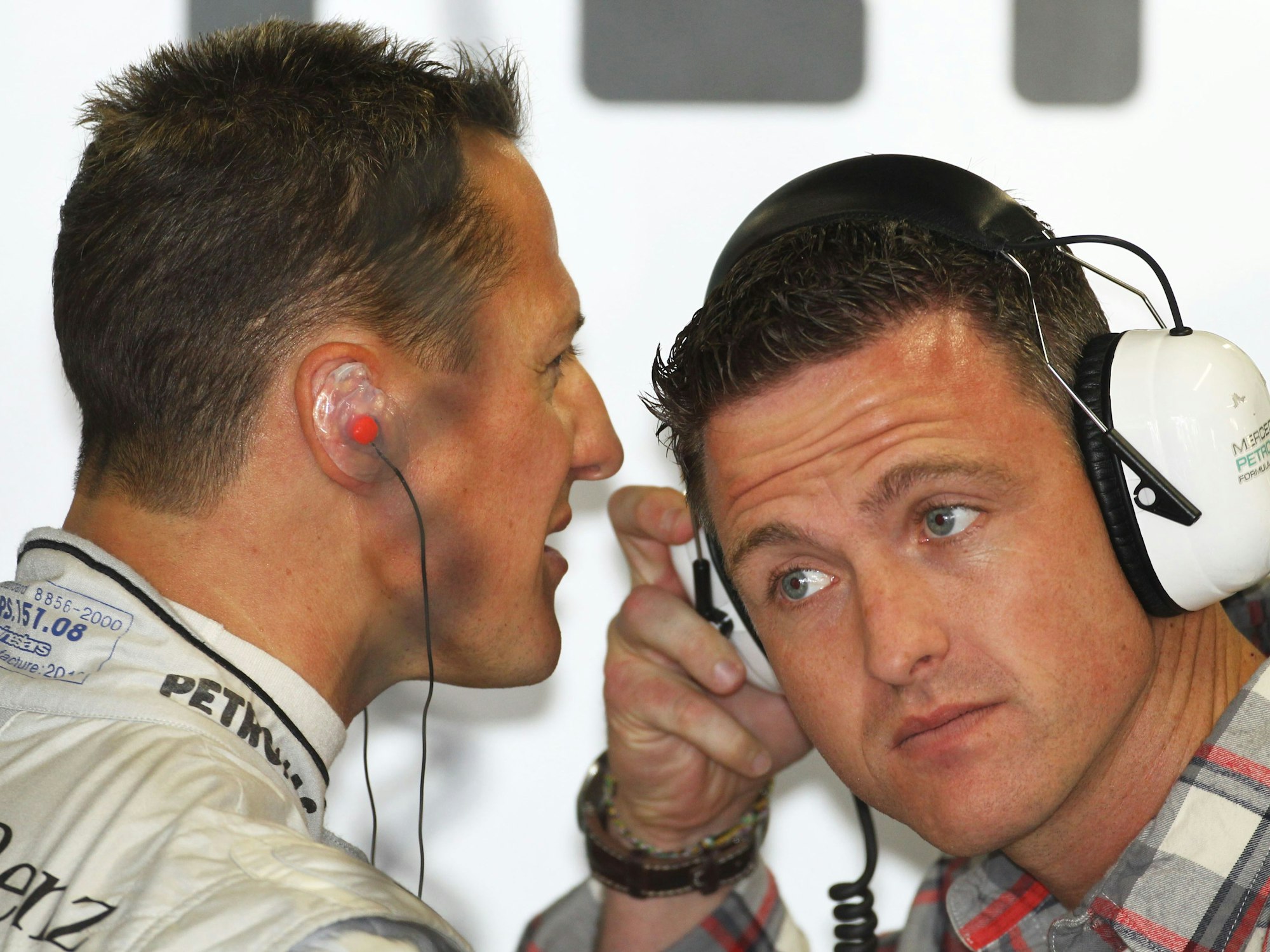 Michael Schumacher (l) von Mercedes GP spricht im zweiten Training auf der Formel-1-Rennstrecke von Suzuka in Japan mit seinem jüngeren Bruder Ralf.