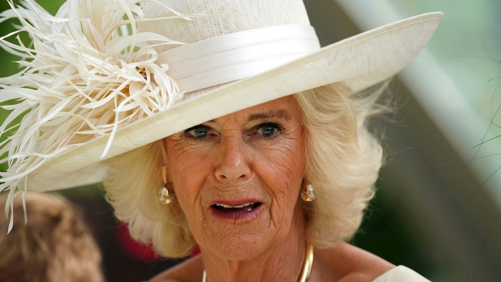 Königin Camilla mit Hut und Federn.