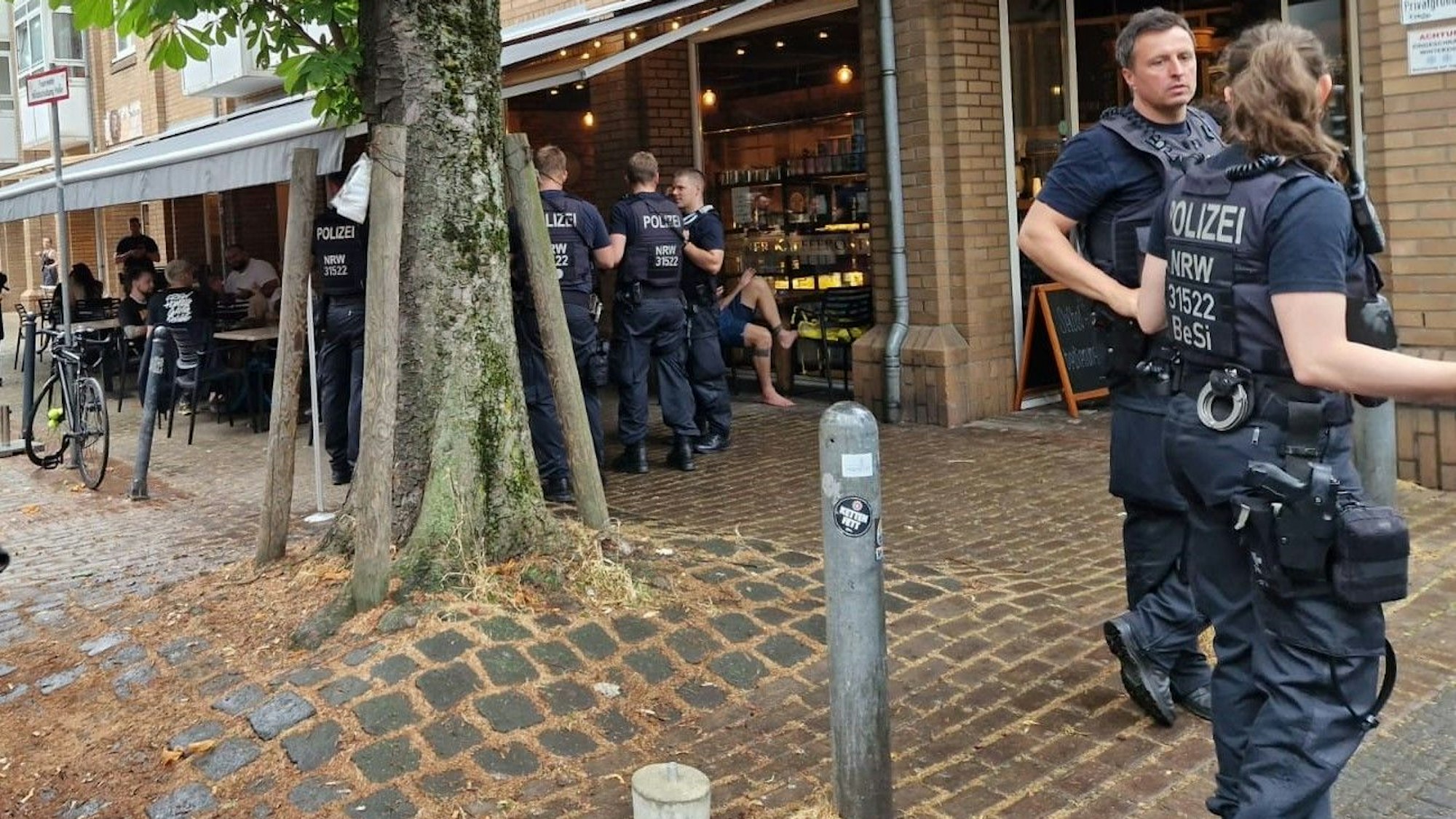 Polizisten und Polizistinnen stehen vor dem Café „Roastery“.