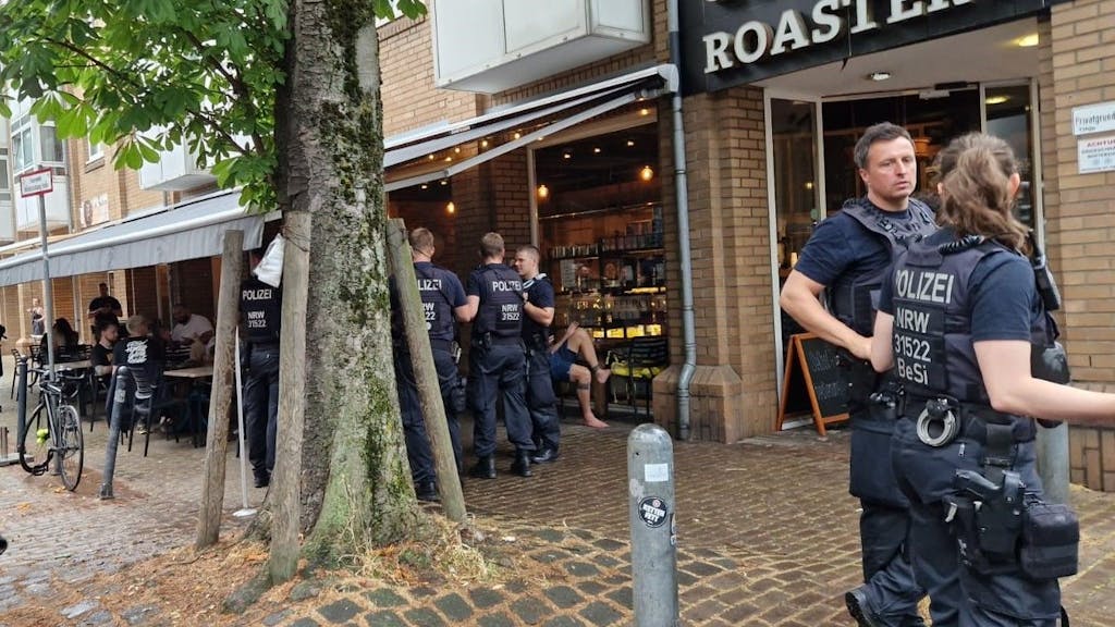 Polizisten und Polizistinnen stehen vor dem Café „Roastery“.