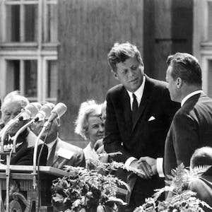 US-Präsident John F. Kennedy (M.) reicht dem Regierenden Bürgermeister von Berlin, Willy Brandt (rechts neben ihm), vor dem Schöneberger Rathaus in Berlin am 26. Juni 1963 die Hand. Mit dem legendären deutsch gesprochenen Satz "Ich bin ein Berliner" drückte Kennedy in seiner Rede seine Verbundenheit mit den Menschen in der geteilten Stadt aus.