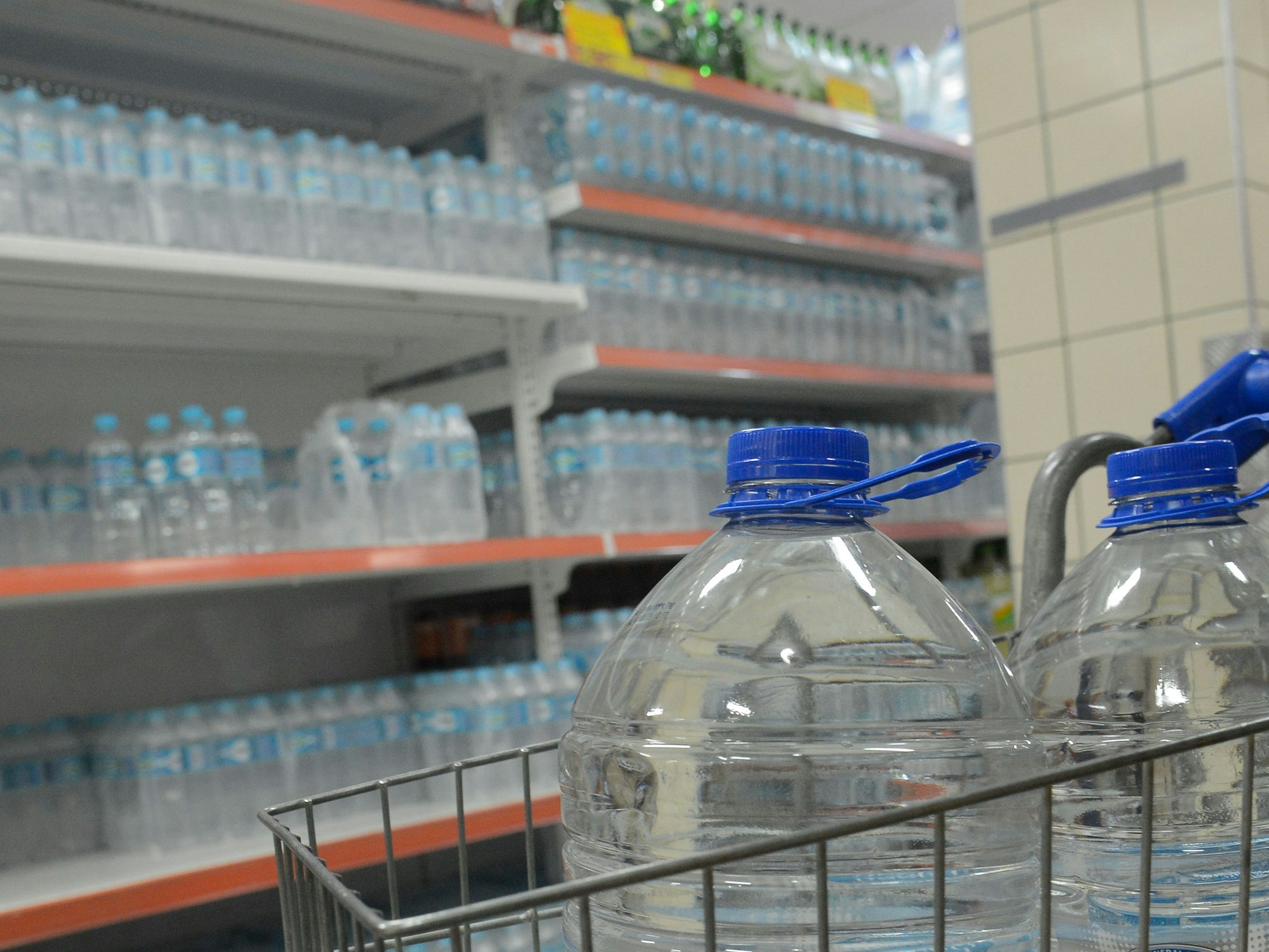 Wasserflaschen stehen in einem Einkaufswagen und auf einem Regal in einem Supermarkt in Rio de Janeiro.