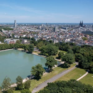 Der Aachener Weiher und das Stadtpanorama. Im Hintergrund sind der Colonius, der Köln-Tower im Mediapark und der Kölner Dom zu erkennen.