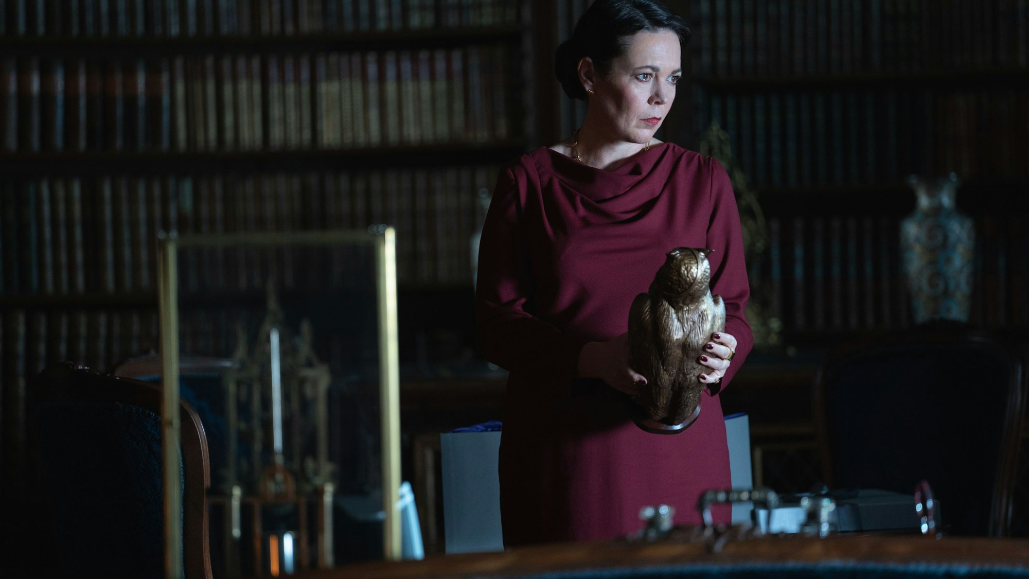 Olivia Colman als Special Agent Sonya Falsworth hält eine bronzene Eule in der Hand.