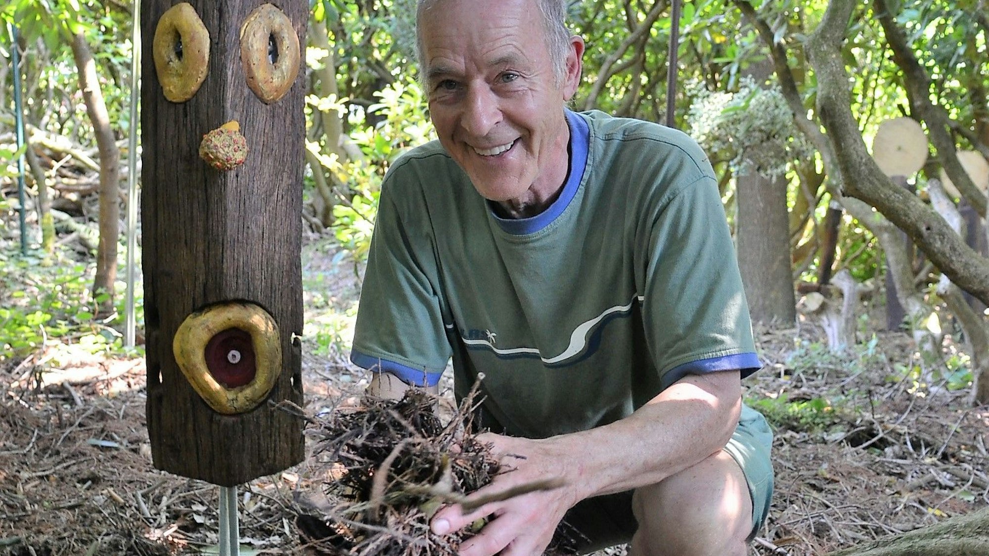 Gartenbesitzer Günther Meyer hält Mulch von einem Mammutbaum in den Händen.