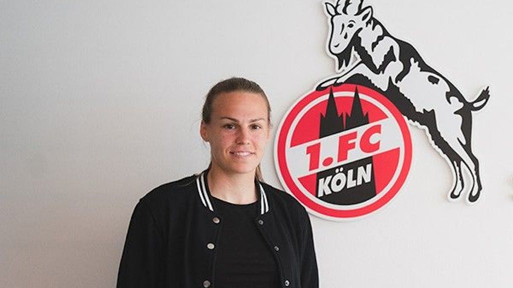 Dora Zeller vor dem Logo des 1. FC Köln.