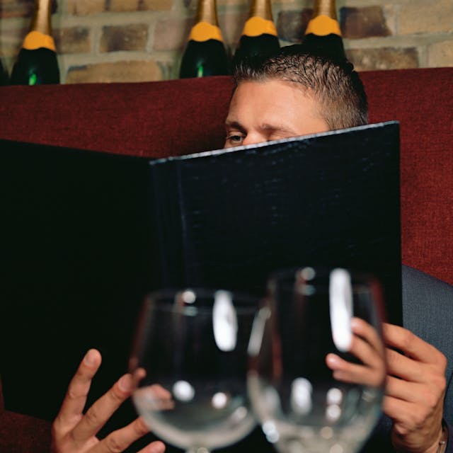 Mann liest die Weinkarte im Restaurant