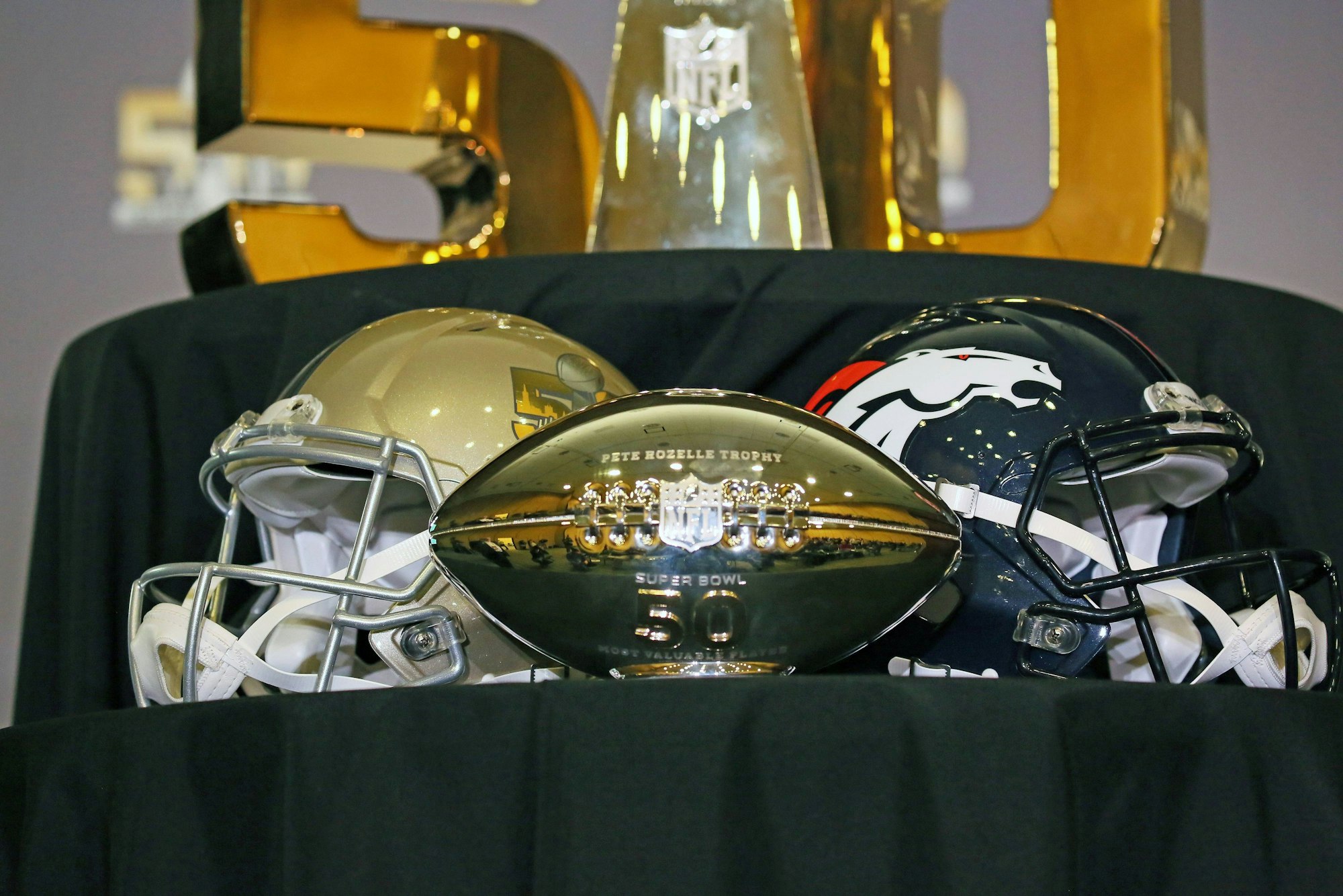 Zwei Helme liegen hinter der Pete Rozelle Trophy.