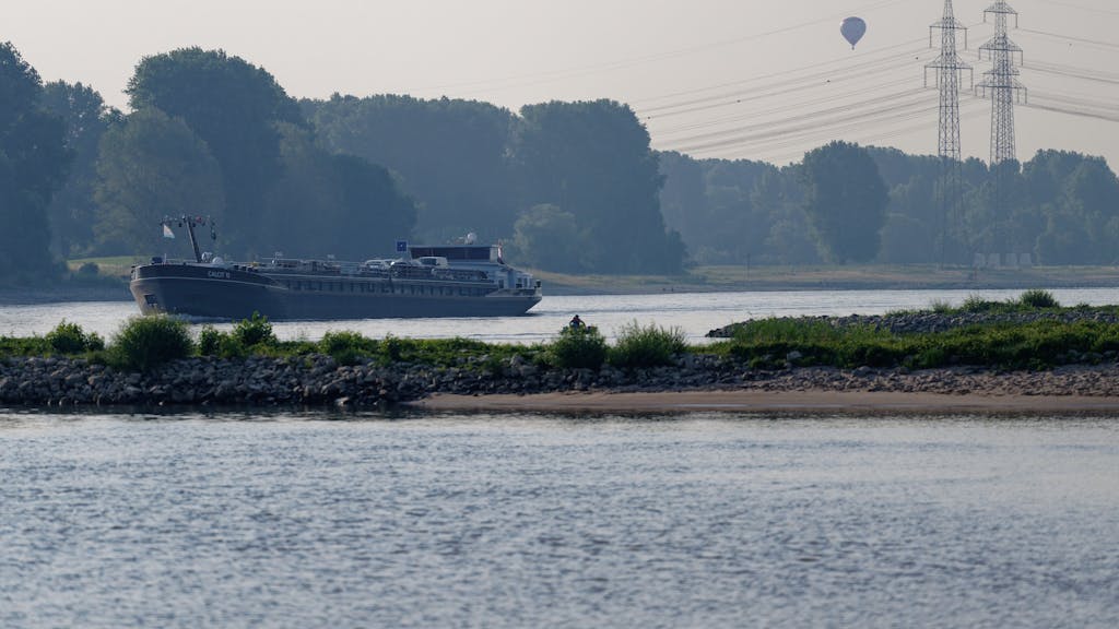 Ein Schiff fährt am Morgen auf dem Rhein bei Köln-Langel.