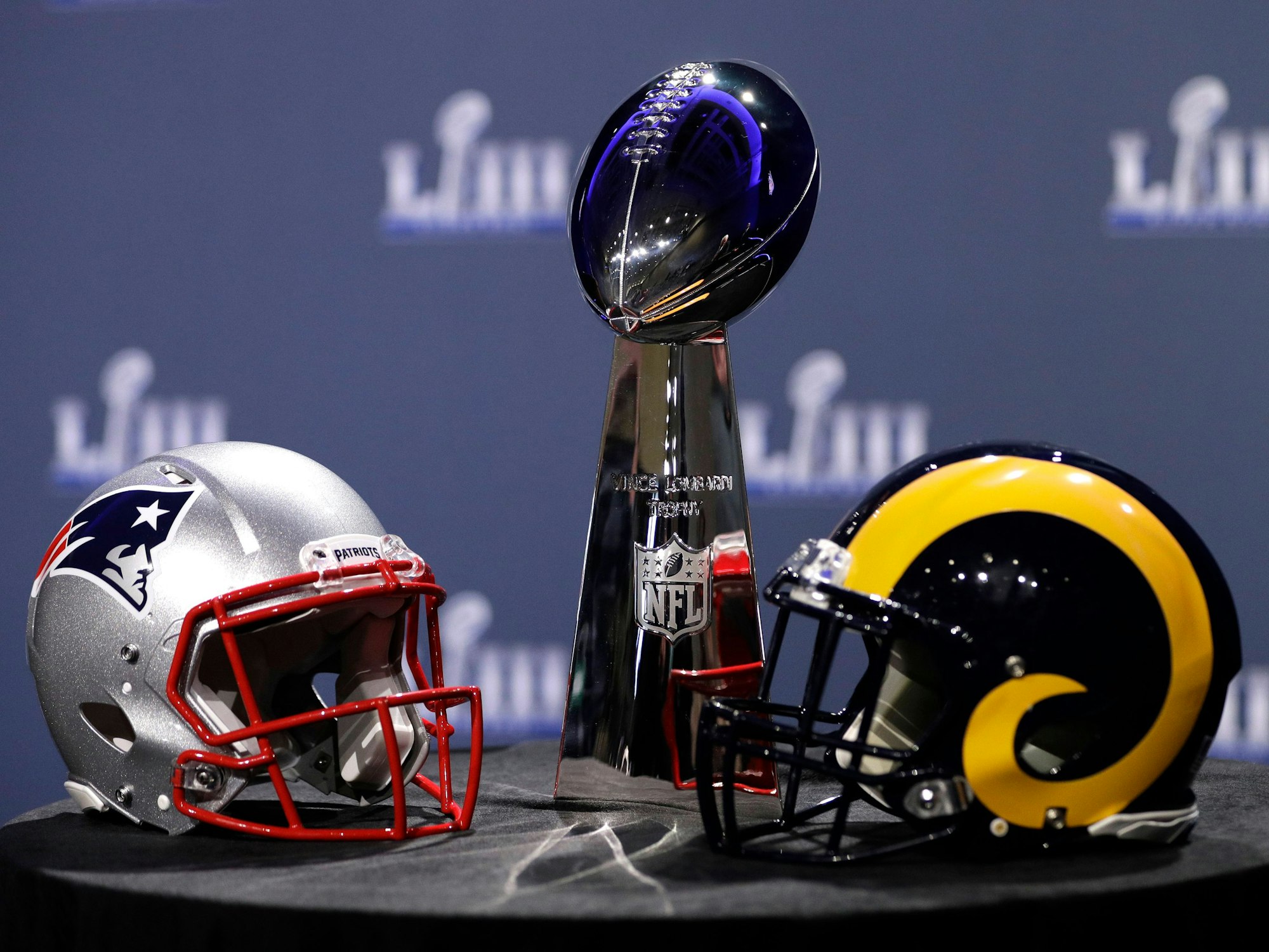 Die Vince Lombardi Trophy, der Pokal, den der Sieger des Super Bowls erhält, steht zwischen den Helmen der beiden Finalisten aus dem Jahr 2019, den New England Patriots und den Los Angeles Rams.