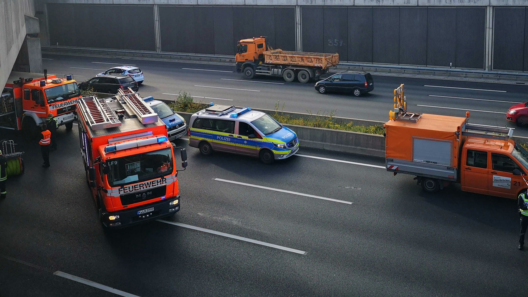 Einsatzfahrzeuge von Feuerwehr und Polizei bei einem Unfall auf der A3 bei Köln.
