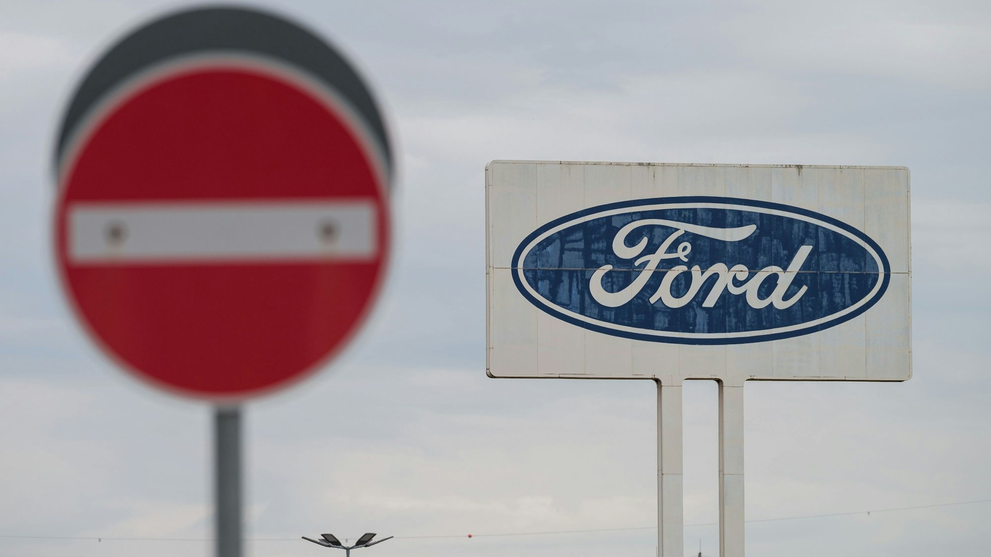 Das große Logo von Ford, das auf dem Parkplatz des Werks Saarlouis steht, mit einem Durchfahrt Verboten Schild davor. Der zweitgrößte US-Autobauer Ford muss zahlreiche Fahrzeuge wegen Brandrisiken reparieren. +++ dpa-Bildfunk +++