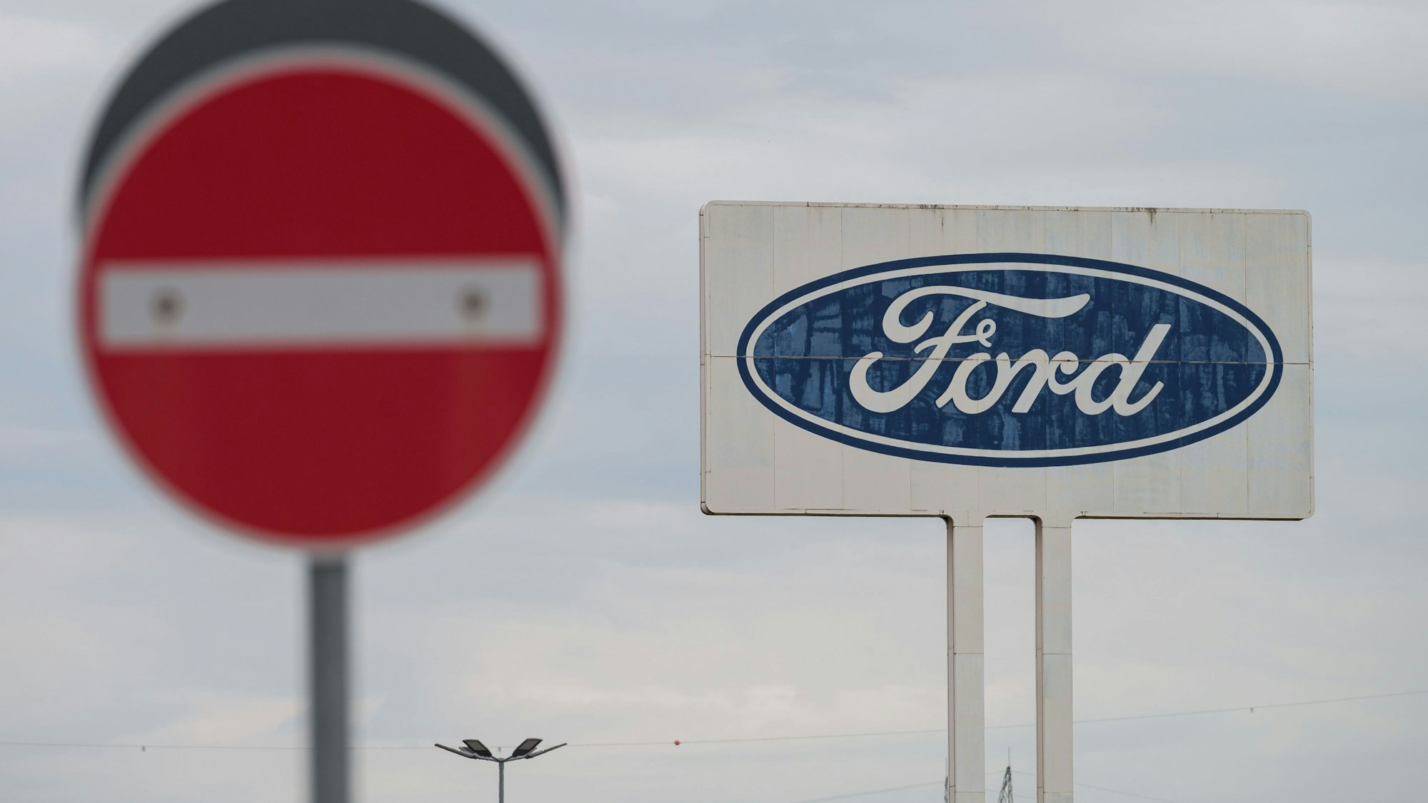 Das große Logo von Ford, das auf dem Parkplatz des Werks Saarlouis steht, mit einem Durchfahrt Verboten Schild davor. Der zweitgrößte US-Autobauer Ford muss zahlreiche Fahrzeuge wegen Brandrisiken reparieren.