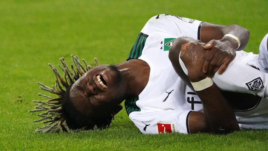 Gladbach-Profi Manu Koné ist am Knie verletzt. Auf diesem Foto ist der U21-Nationalspieler Frankeichs am 31. Oktober 2021 zu sehen. Er liegt mit schmerzverzerrtem Gesicht auf dem Spielfeld.
