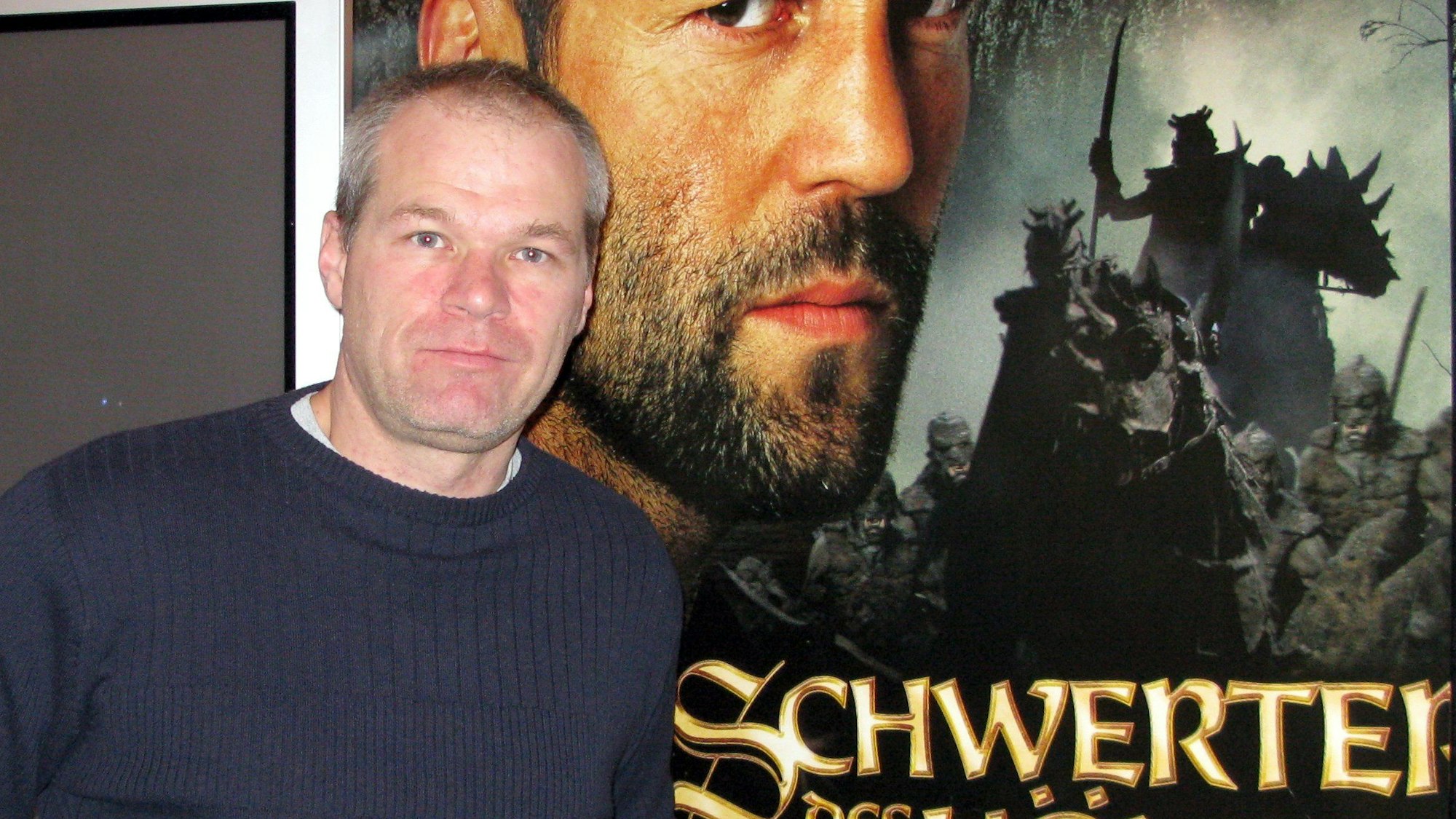 Der Filmemacher Uwe Boll steht am Montag (26.11.2007) in Mainz vor dem Plakat seines Fantasy-Epos „Schwerter des Königs“.