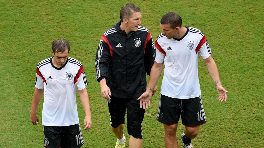 Philipp Lahm, Bastian Schweinsteiger und Lukas Podolski laufen über das Feld.