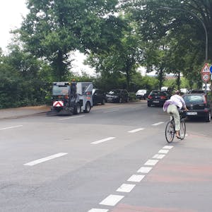 Ein Radfahrer wechselt von der Straße auf den Radfahrstreifen auf dem Gehweg.