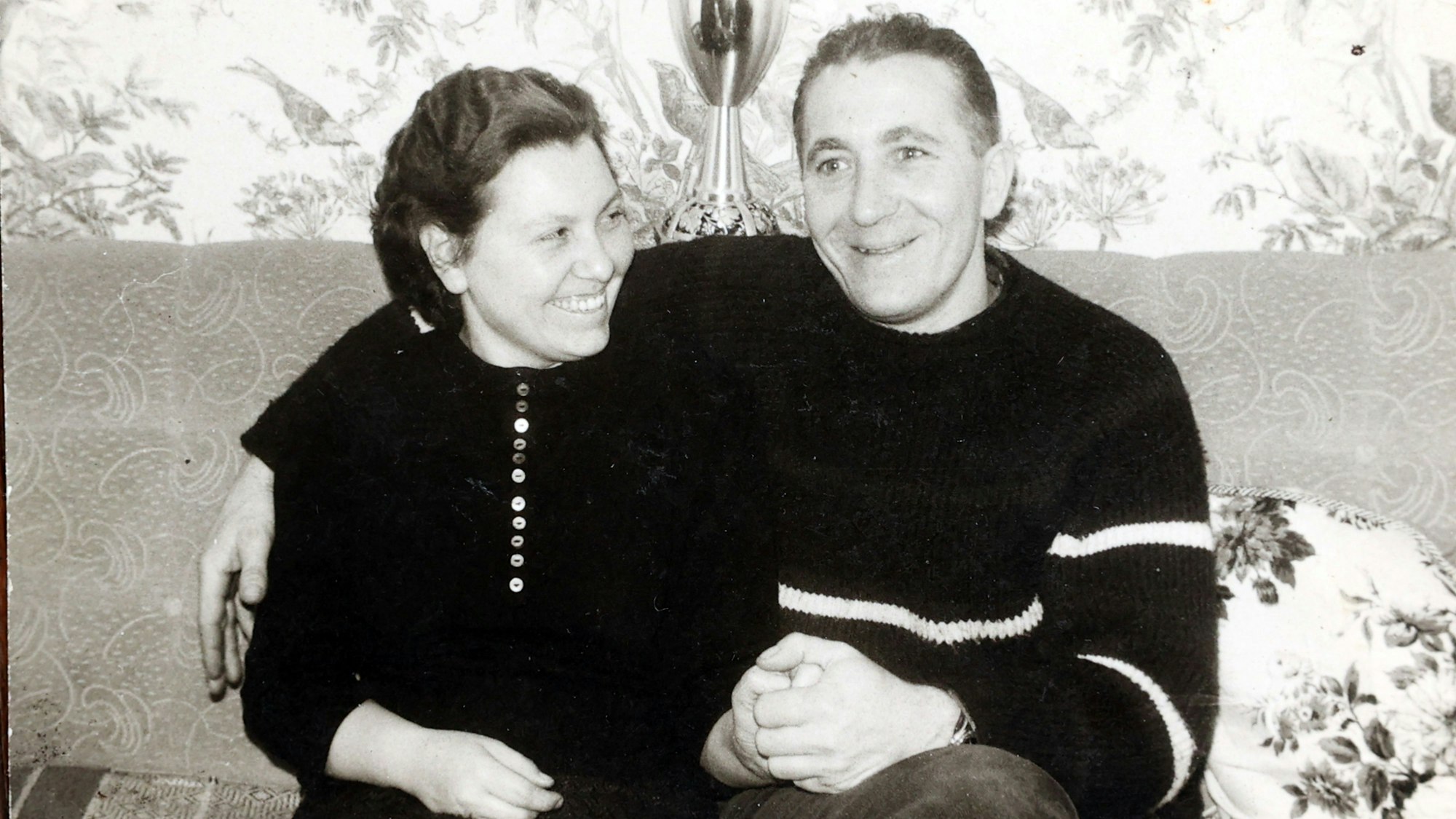 Das Bild zeigt eine Schwarz-Weiß-Aufnahme, auf der Katharina und Johann Wirotius auf einem Sofa sitzen.