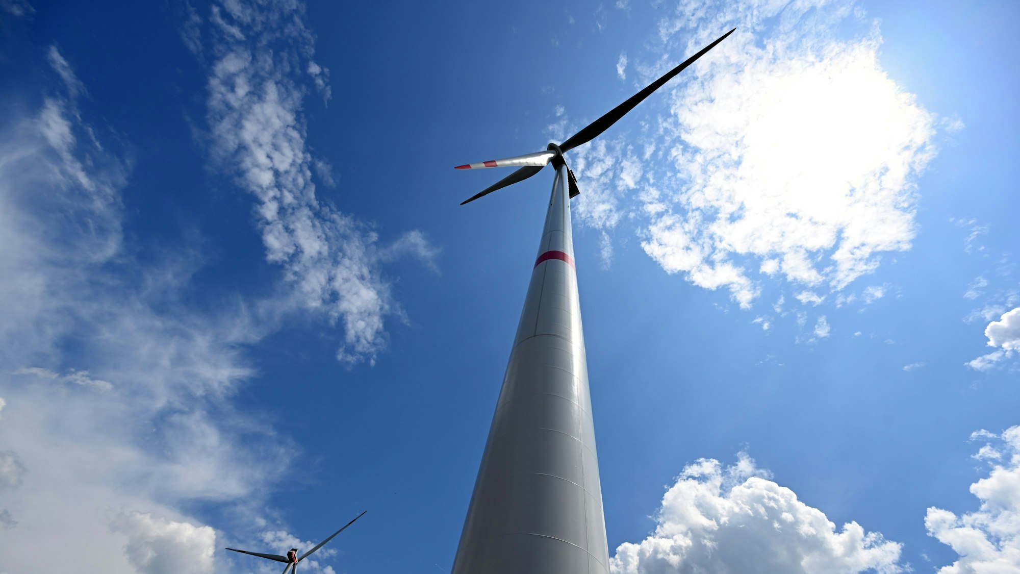 Wolken ziehen über Windräder zur Stromerzeugung. Die Wittgenstein Gruppe sowie der Landesverband Erneuerbare Energien NRW nehmen den seit Herbst 2022 bestehenden Wald-Windpark Arfeld mit vier Windrädern offiziell in Betrieb.