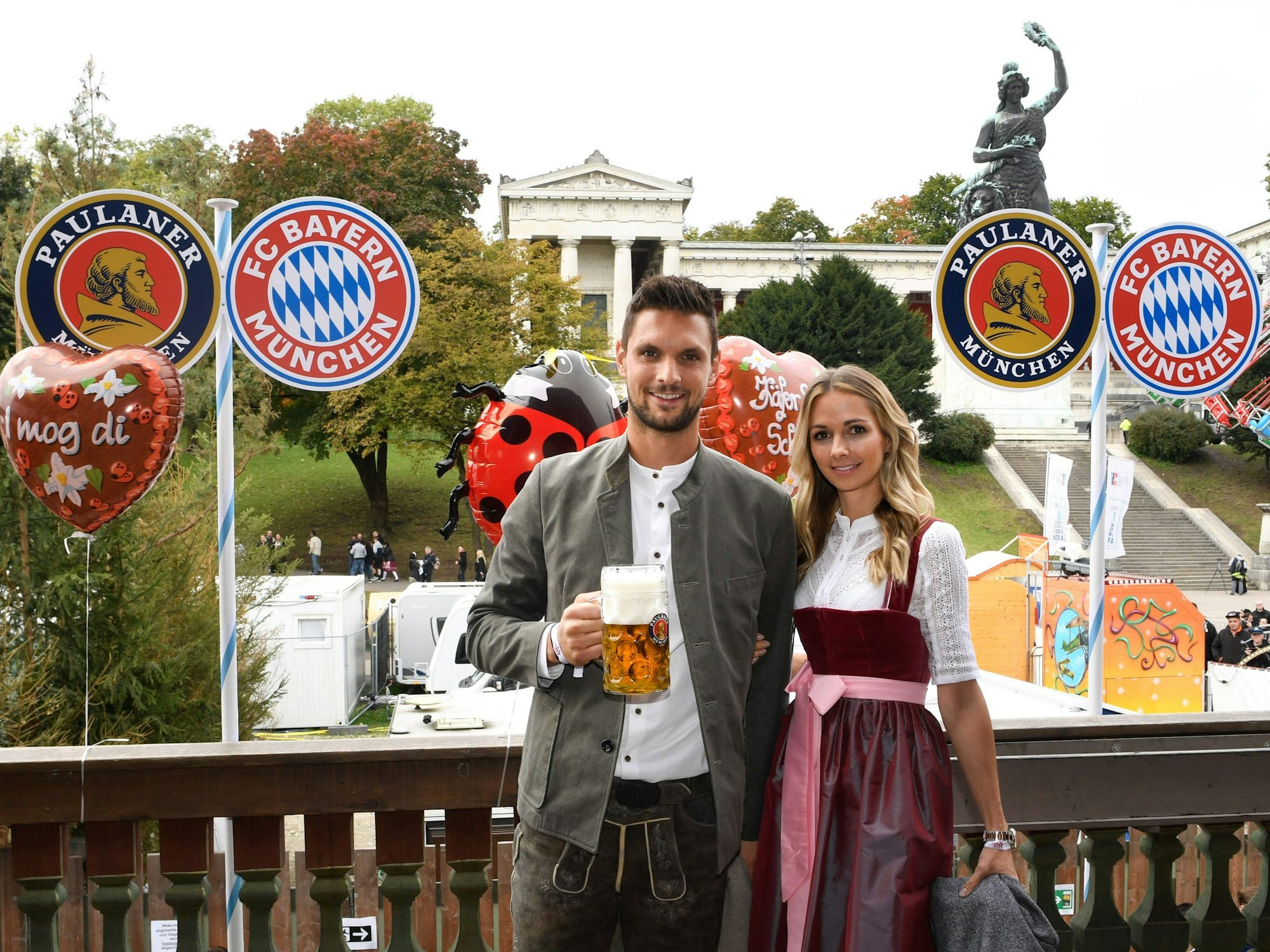 Sven Ulreich vom FC Bayern München und seine Ehefrau Lisa stehen auf einem Balkon des Käferzelts auf dem Oktoberfest in München.