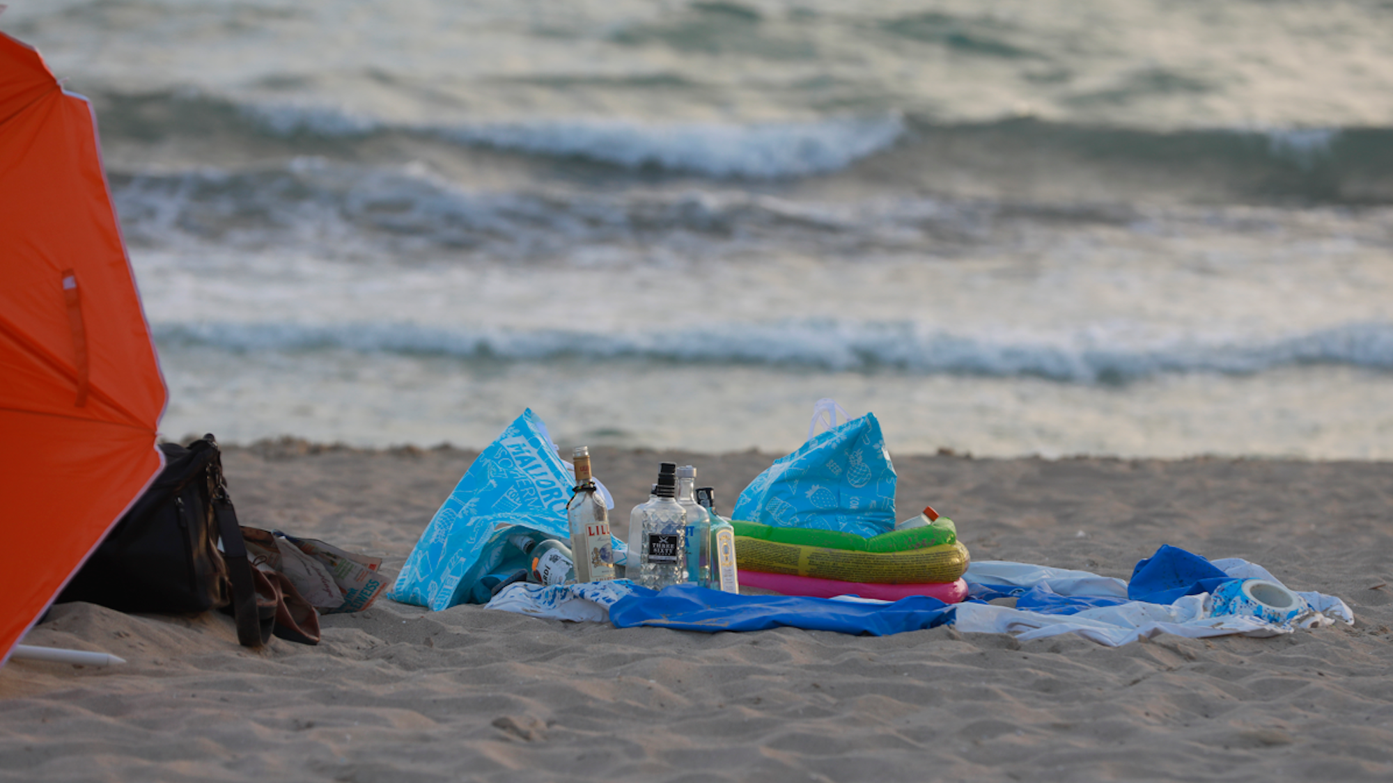 Leere Flaschen alkoholischer Getränke stehen am Strand von Arenal.