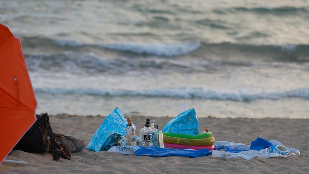 Leere Flaschen alkoholischer Getränke stehen am Strand von Arenal.