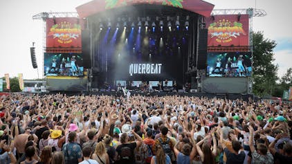 Viele Menschen stehen vor der Bühne des Summerjam-Festivals auf der gerade Querbeat auftreten.